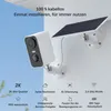 A white security camera with a solar panel attached, mounted on a white wall. Náhled obrázku produktu