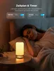 A woman sleeping in bed next to a glowing bedside lamp. Produktbild-Vorschau