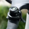 A close-up shot of a black bicycle bell attached to the handlebar. Podgląd zdjęcia produktu