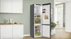 A kitchen scene with an open refrigerator and cabinets. Produktbild-Vorschau