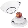 A clear plastic bowl sits above a white mechanical kitchen scale with a red apple on top. The scale has a circular dial with markings in kilograms. Voir les images du produit