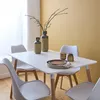 A dining table with chairs, set with decorative items and plates, in a room with a yellow wall. Anteprima dell’immagine prodotto