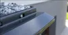 Close-up of a gray gutter profile with small stones on top. Produktbild-Vorschau