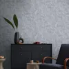 A modern living room scene with a dark dresser, a chair, and decorative items. Produktbild-Vorschau