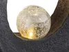 A close-up of a decorative cracked glass sphere with embedded lights, resting within a dark, textured frame. Anteprima dell’immagine prodotto
