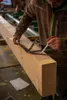 A person is marking a large wooden beam with a measuring tool and pencil. Anteprima dell’immagine prodotto