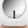 A white rectangular basin with a black faucet is shown in front of a large round mirror. Náhľad obrázku produktu