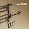 A black towel warmer with hooks and a shelf, mounted on a wall with shadows cast. Anteprima dell’immagine prodotto
