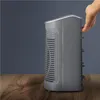 A hand is shown adjusting a gray heater on a wooden table against a dark gray background. Anteprima dell’immagine prodotto