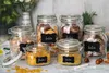 A collection of glass jars filled with various food items, such as cookies and cereal, arranged on a countertop. Produktbild-Vorschau
