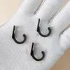 Three small metal hooks are placed on a white fabric glove. Podgląd zdjęcia produktu