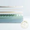 A cross-section of a mattress showing its different layers, with a quality seal in the foreground. Produktbild-Vorschau