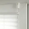 A close-up view of a white pleated blind mechanism attached to a window frame. Produktbild-Vorschau