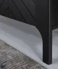 Close-up of the leg and base of a black wooden dresser or cabinet, with a rug partially visible in the foreground. Produktbild-Vorschau