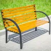 A wooden and metal park bench sits on a paved walkway next to a grassy area. Anteprima dell’immagine prodotto