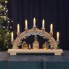 A wooden Christmas arch with candle lights and miniature village scene. Podgląd zdjęcia produktu