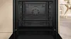 An open, empty oven interior with a fan and racks visible. Produktbild-Vorschau