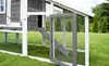 A close-up view of a gray and white chicken coop with an open door and ramp, set on a green lawn. Produktbild-Vorschau
