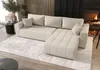 A modern living room with a sectional sofa, fireplace, and decorative elements. Voir les images du produit