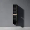 A tall, narrow cabinet with shelves against a concrete wall. Anteprima dell’immagine prodotto