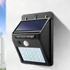 A solar-powered wall light with LED lights and a PIR sensor is mounted on a textured white wall. Produktbild-Vorschau