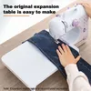 A person is using a sewing machine with an expansion board attached, sewing a pair of jeans. Produktbild-Vorschau