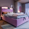 A pink upholstered bed with a tufted headboard and built-in LED lighting, set in a bedroom with a window and decorative elements. Náhled obrázku produktu