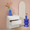 A white dresser with an open drawer, decorated with blue vases and flowers, next to an arched mirror. Anteprima dell’immagine prodotto