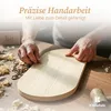 A craftsman's hands working on a wooden object, with wood shavings and tools on a table. Produktbild-Vorschau