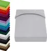 A stack of folded fabric swatches in various colors is shown on the left, and a light gray fitted sheet is displayed on the right. Produktbild-Vorschau