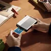 A person is holding a portable photo printer and a photo is being printed. Anteprima dell’immagine prodotto