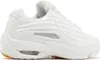A side view of a white Nike NOCTA Hot Step 2 sneaker with a yellow sole. Podgląd zdjęcia produktu