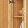 Close-up view of the interior of a wooden cabinet, showing a shelf with bowls and a handle. Produktbild-Vorschau