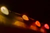 A close-up, diagonal view of a string of C9 LED Christmas lights, transitioning from a bright white bulb to orange, red, and pinkish-red bulbs. Podgląd zdjęcia produktu