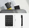 A black numeric keypad is shown in a bag with a phone and a magazine. Podgląd zdjęcia produktu