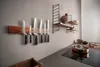 A kitchen scene with knives on a magnetic strip and shelves on the wall. Voir les images du produit