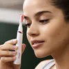 A woman is holding a Philips eyebrow trimmer near her face. Náhled obrázku produktu
