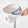 A hand is shown placing items into a toilet paper stand. Voir les images du produit