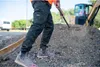 A person is working on a construction site, shoveling dirt. Anteprima dell’immagine prodotto