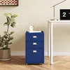 A blue filing cabinet is placed next to a desk with a laptop and a lamp. A plant is on the left side of the image. Voir les images du produit