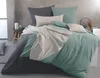 A bed with dark gray, mint green, and beige bedding, styled in a modern bedroom setting. Produktbild-Vorschau