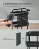 A person's hands are shown attaching a perforated panel to a black rolling cart. The cart has multiple shelves and a handle. The lower part of the image shows a diagram illustrating how the panel attaches with hooks. Produktbild-Vorschau