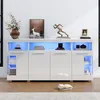 A modern white sideboard with LED lighting, decorated with various items on top. Podgląd zdjęcia produktu