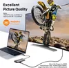 A laptop connected to a docking station, which is then connected to a large monitor displaying a motocross rider. Produktbild-Vorschau