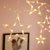 A close-up shot of decorative star-shaped lights hanging against a light pink background. Podgląd zdjęcia produktu