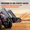 A close-up view of a tractor's front loader with forks attached, in a field during sunset. Anteprima dell’immagine prodotto