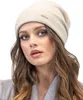A woman wearing a beige beanie and grey coat. Produktbild-Vorschau