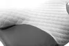 A close-up view of a white orthopedic pillow with a textured hexagonal pattern and a gray mesh fabric underneath. Náhled obrázku produktu