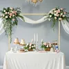 A table set up for a celebration with cakes, flowers, and candles under a decorative arch. Voir les images du produit