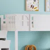 Close-up of a white bunk bed with a decorative window-like panel and a slatted side rail. Two framed pictures are visible on the light blue wall behind the bed, and a pretzel-shaped object is on the surface below. Náhled obrázku produktu